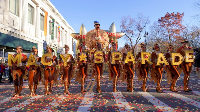 Parade performers lead the Tom Turkey float down Central Park West at the start of the Macy's...