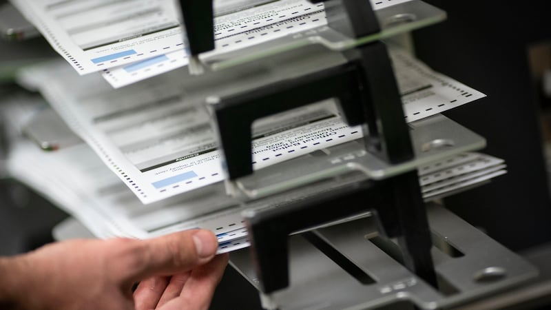 FILE - Poll workers sort out early and absentee ballots at the Kenosha Municipal Building on...